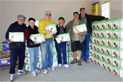Bob & Diane Hall, Bill & Cathy Fagan, Mike Mastrodonato & Mike Zimmerman stacking cases of diapers in the storage unit. (photo by Mac MaGill)